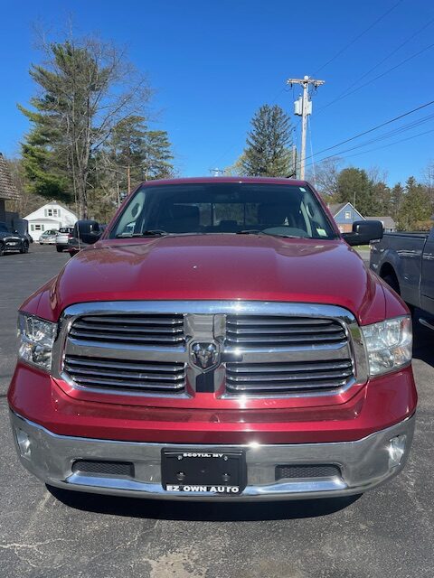Front view of a red Dodge Ram pickup truck parked in a lot.