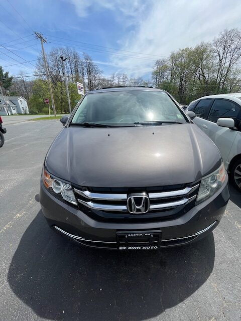 Front view of a gray Honda SUV parked in a lot, with a dealership plate frame on the front bumper.