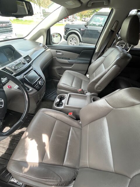 Interior of a grey SUV showing front seats, center console with cup holders, and dashboard.