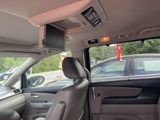 Ceiling-mounted flip-down entertainment screen inside a car, deployed above the front seats for rear passengers