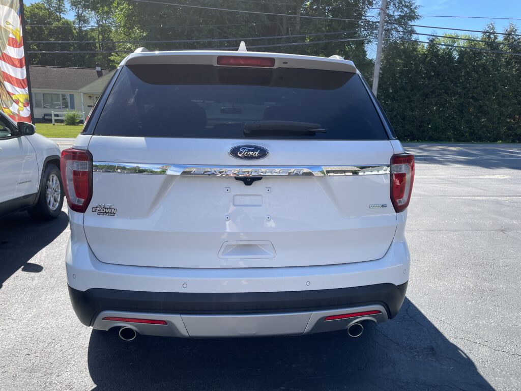 Rear view of a white Ford Explorer SUV in a parking lot, chrome 'EXPLORER' badge visible